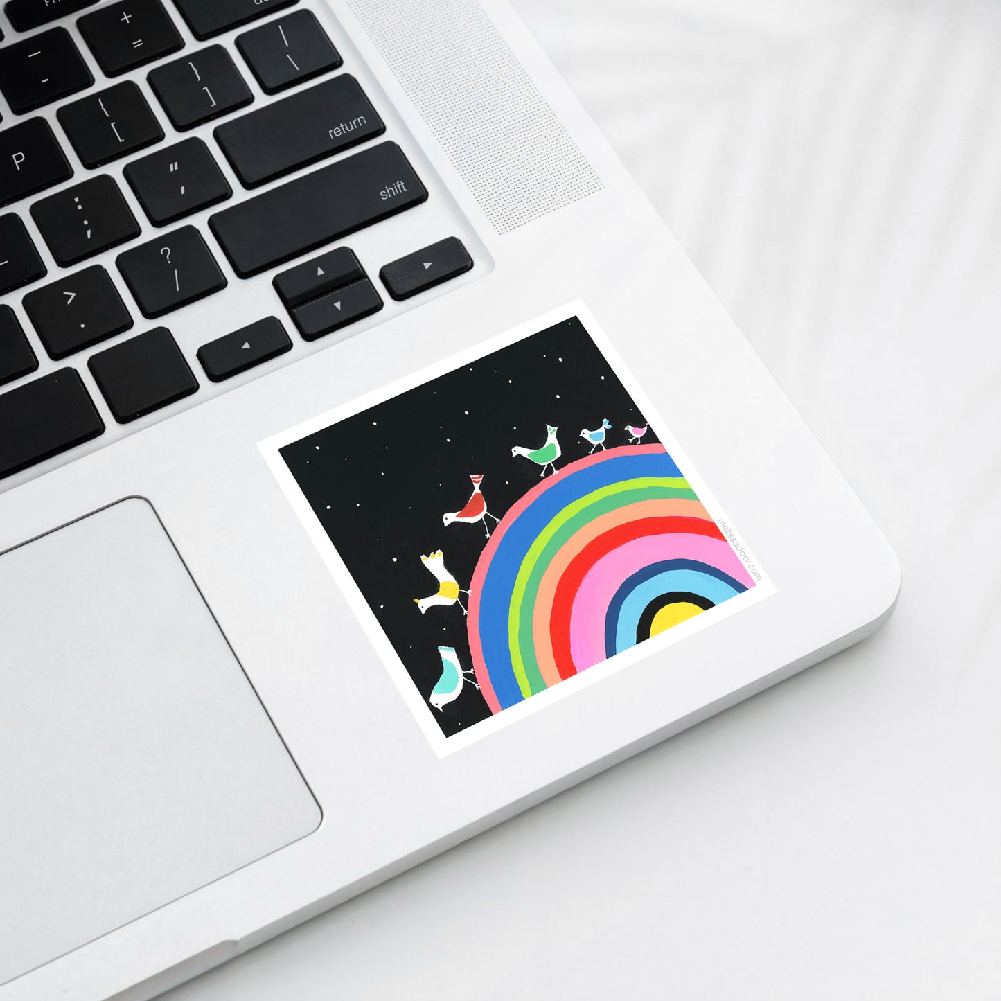 Laptop with a colorful rainbow and character design on the screen