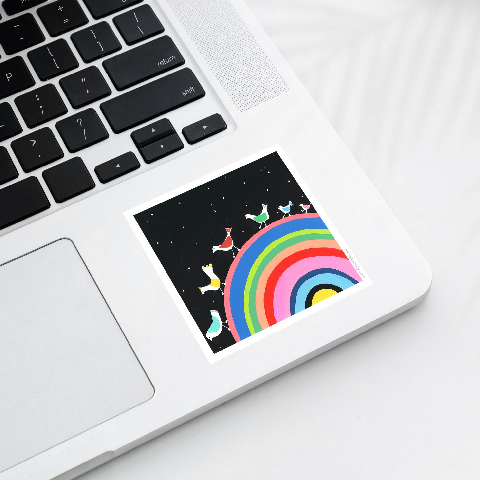 Laptop with a colorful rainbow and character design on the screen