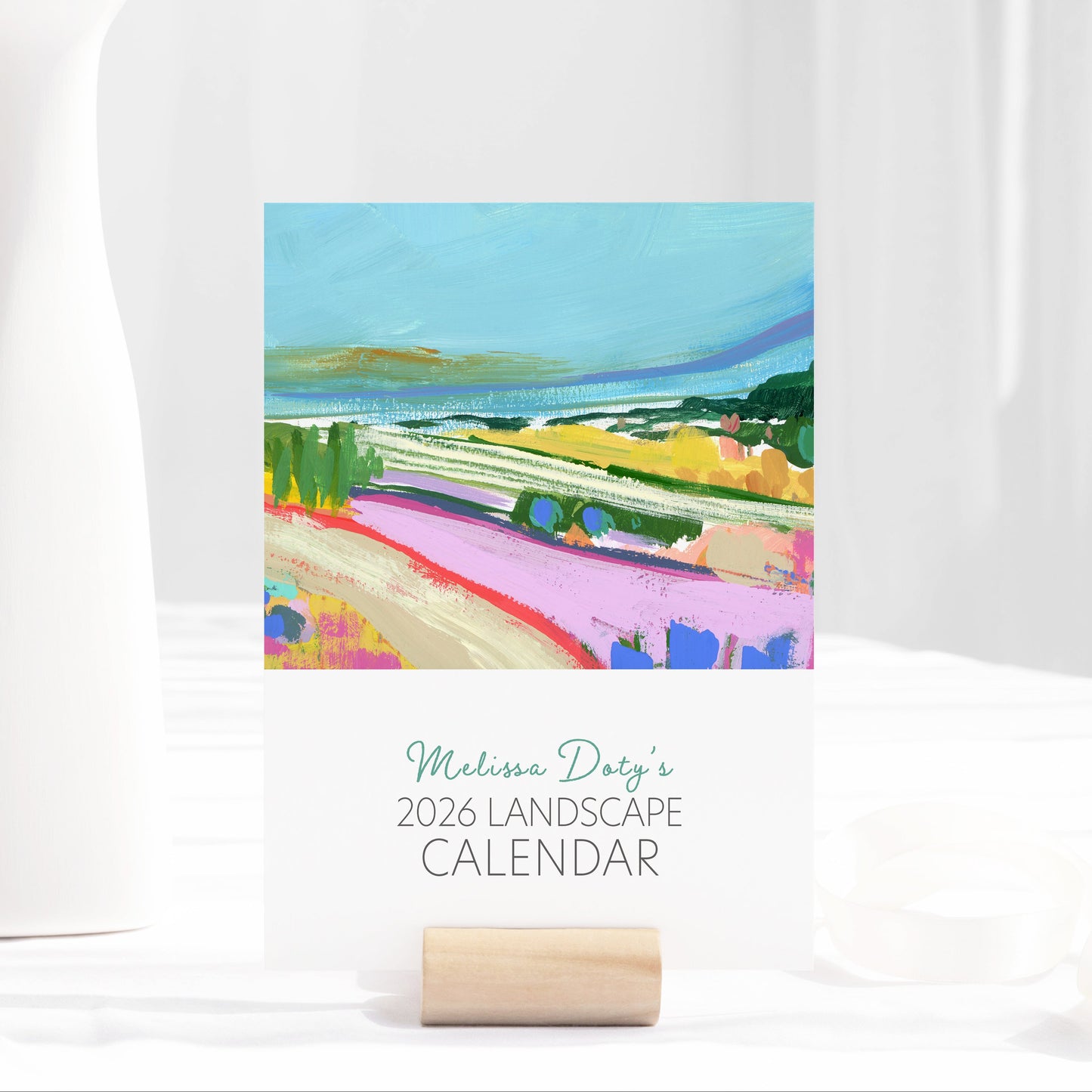 2026 desktop sized landscape art calendar by Melissa Doty on a white surface with a scenic cover.