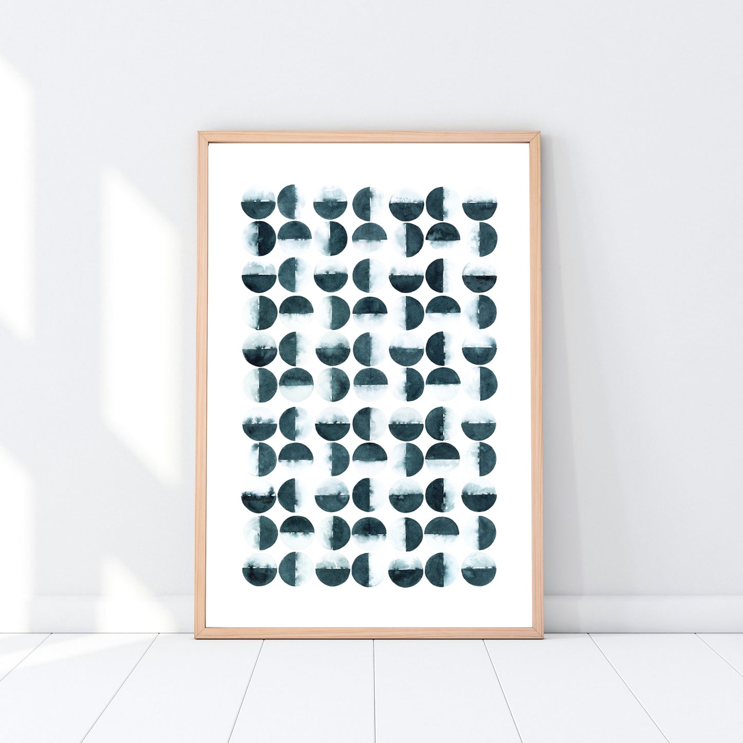 Framed abstract art print with geometric shapes on a white wall.